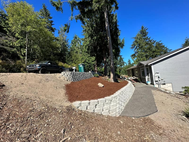 Stack-block retaining wall with paver walkway and step transitions installed in Carlsborg, Washington