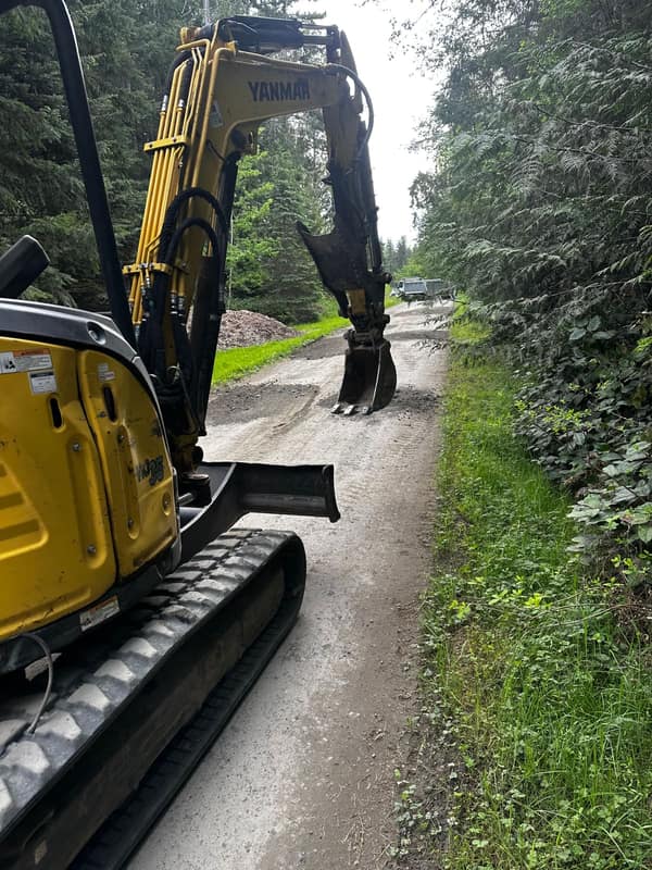 Yanmar mini excavator and dump trailer working a hardscape jobsite on the Olympic Peninsula