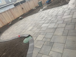 Hardscape install in progress — paver base preparation + edge work