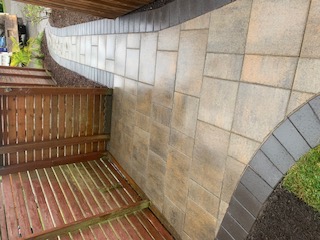 Tan paver walkway with charcoal-paver border curving through yard